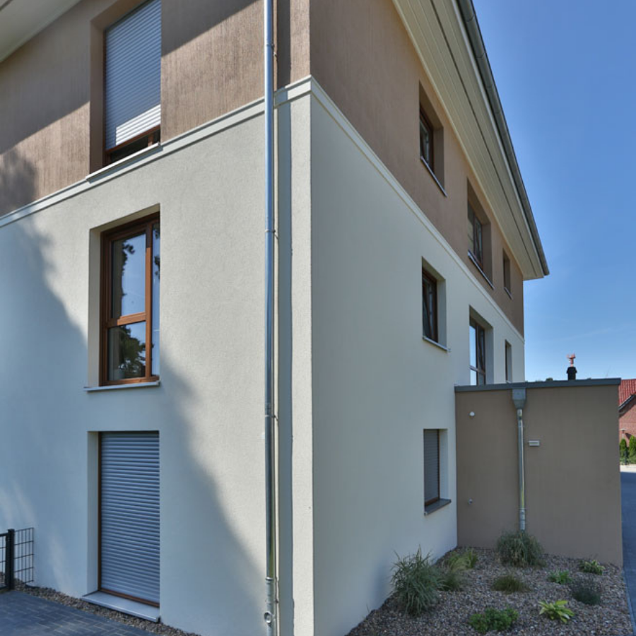 Modernisierte Putzfassade eines Wohnhauses in zweifarbiger Ausführung – Beispiel für hochwertige Fassadensanierung und Wärmedämmung.