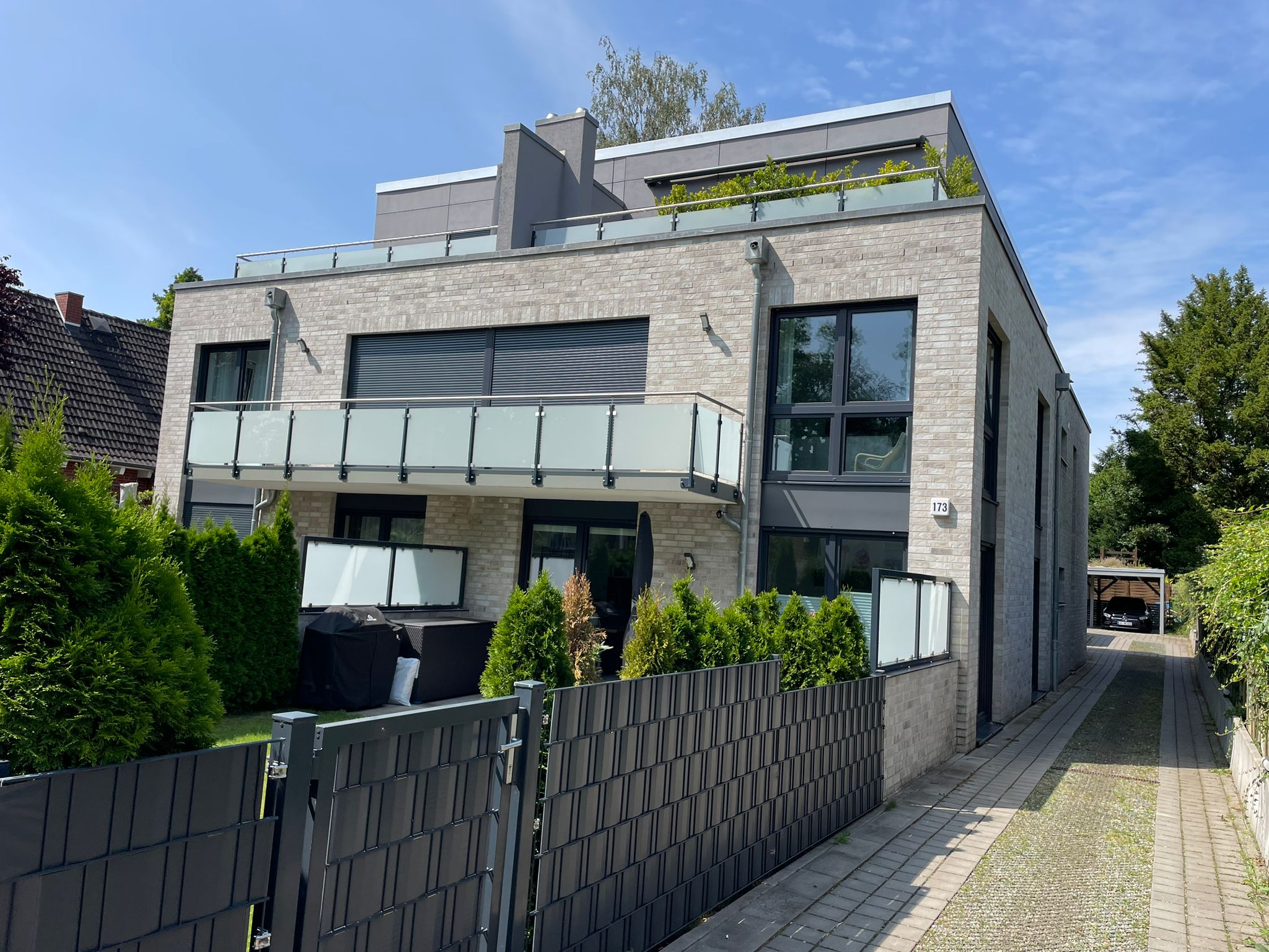 Modernes Mehrfamilienhaus mit stilvollen Glasbalkonen – Beispiel für zeitgemäße Balkonsanierung und hochwertige Fassadengestaltung.