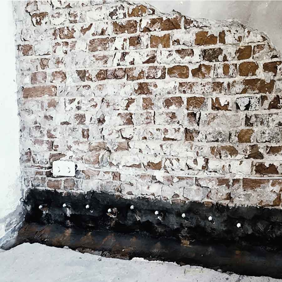 Von Marquardt Bausanierung durchgeführte Horizontalsperre gegen aufsteigende Feuchtigkeit: Nahaufnahme einer Ziegelwand mit Bohrlöchern für die Injektion. Von Marquardt Bausanierung durchgeführte Horizontalsperre gegen aufsteigende Feuchtigkeit: Nahaufnahme einer Ziegelwand mit Bohrlöchern für die Injektion.