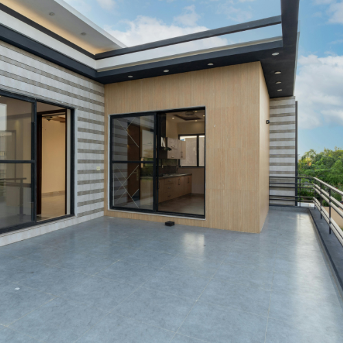 Modernes Terrassendesign mit klarer Linienführung und Glasgeländer – stilvolle Erweiterung des Wohnraums im Außenbereich.