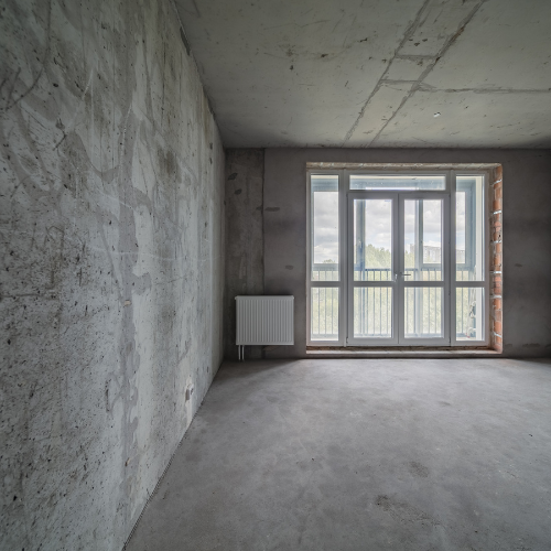 Rohbau mit Betonwand und Fensteröffnung – Vorbereitung für Verpressarbeiten zur Abdichtung gegen Feuchtigkeit und Risse.